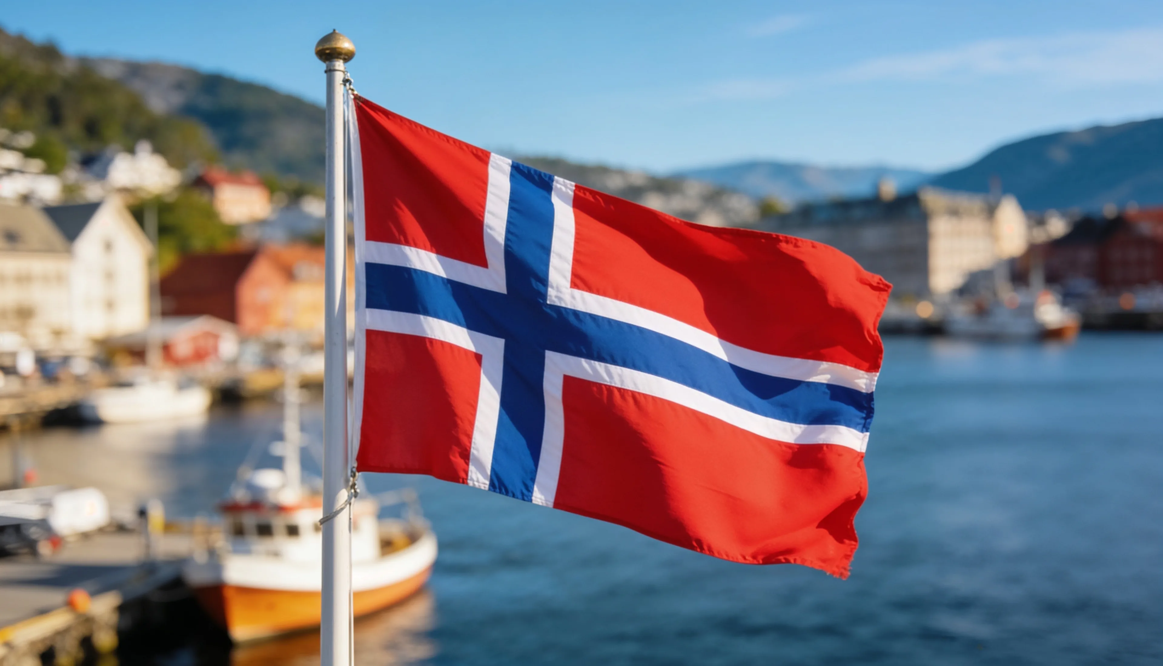 Flag of Norway flying at a fjord harbour - marine spare parts delivered to Norway from India